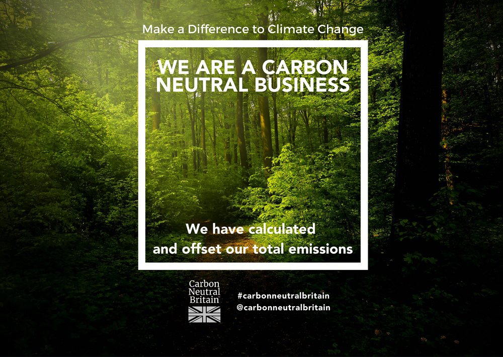 Text 'We are a Carbon Neutral Business' over a forest, with 'Carbon Neutral Britain' logo and Union Jack flag.