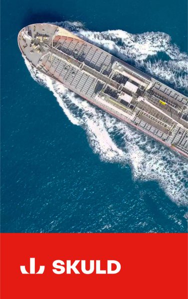Aerial view of a cargo ship on blue water, with the Skuld logo and name on a red background.